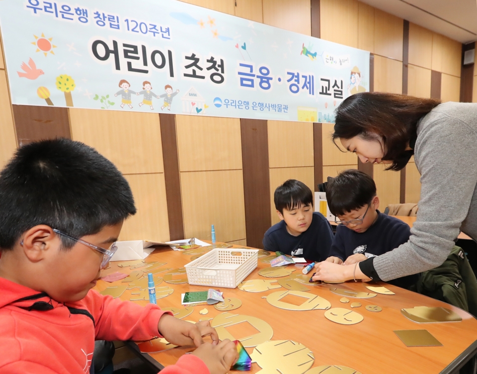 우리금융그룹은 지난달 30일 서울시 중구에 소재한 우리은행 박물관에서 유치원생, 초등학생들을 대상으로 ‘어린이 금융·경제교실’을 개최했다. 어린이들이 황금돼지 저금통을 직접 만들고 있다.(사진=우리금융)