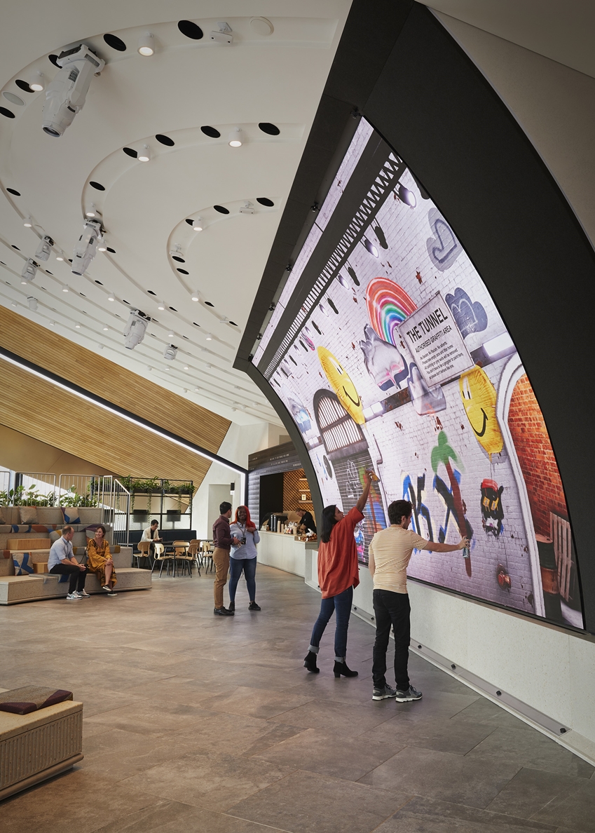 ▲ 영국 런던에 있는 쇼핑몰 ‘콜 드롭스 야드’에 위치한 ‘삼성 킹스크로스’에서 관람객들이 초대형 커브드 LED 스크린에 직접 그림을 그리고 있다./사진=삼성전자